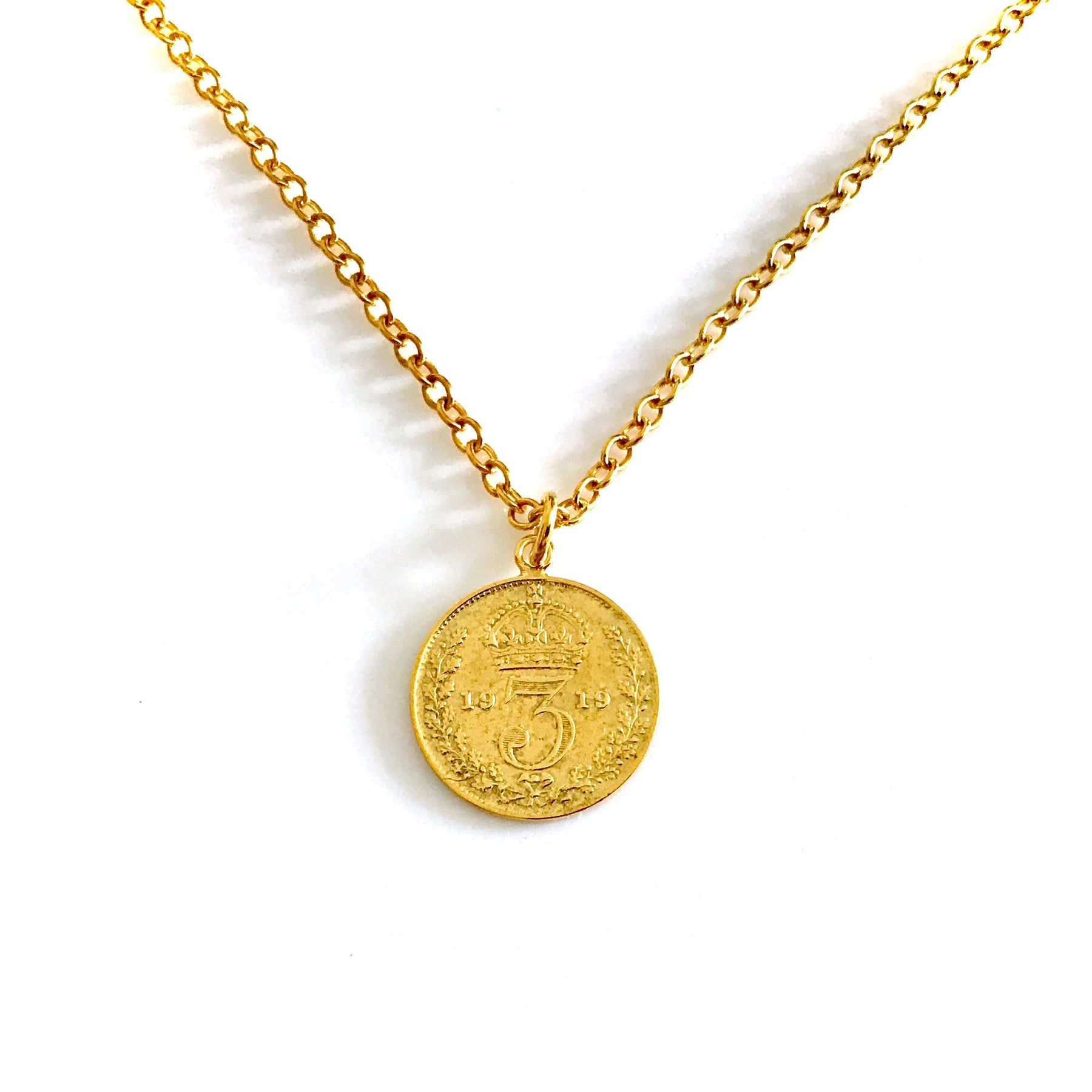 A gold coin necklace featuring an old British design