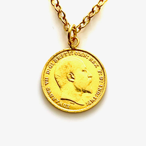 Close-up of vintage gold plated 1905 threepence coin pendant