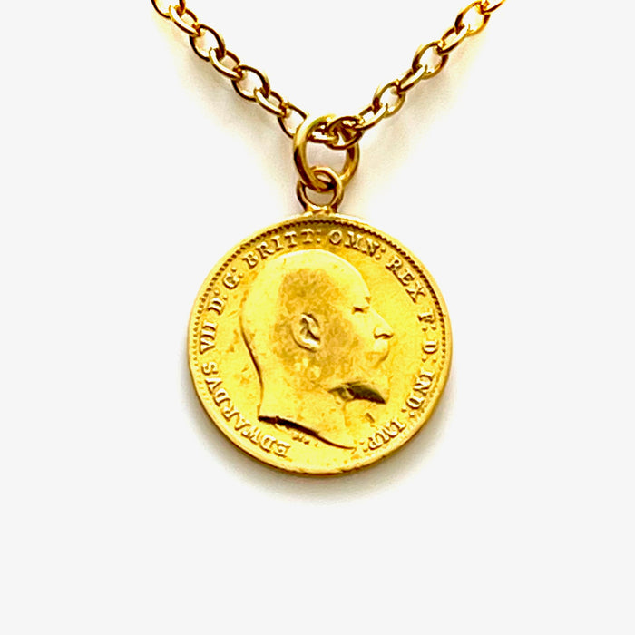Close-up of gold vermeil 1906 threepence coin pendant with intricate design